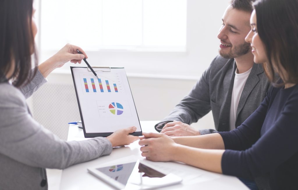 Financial advisor showing payments plan to young couple